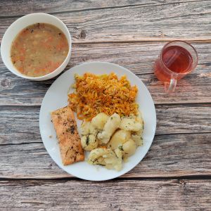Zdjęcie przedstawia Dietę z ograniczeniem łatwoprzyswajalnych węglowodanów  Krupnik jęczmienny Łosoś pieczony z przyprawami Ziemniaki młode z koperkiem gotowane Surówka z młodej kapusty Kompot owocowy z jabłkami